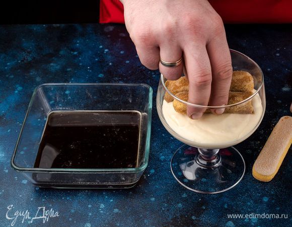 Затем выложите слой крема, снова добавьте пропитанный в кофе савоярди и слой крема. 