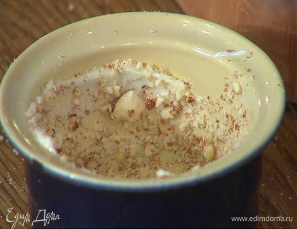 Небольшие керамические формы для выпечки смазать оставшимся сливочным маслом и обсыпать дно и стенки измельченным миндалем.