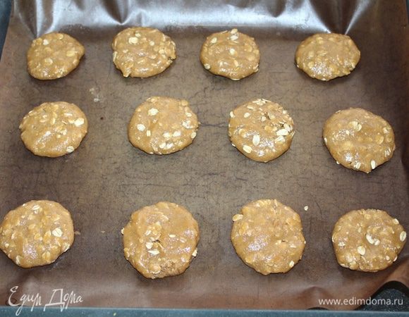 Скатайте тесто в шарики и выложите на противень с бумагой, оставляя место между печеньем.