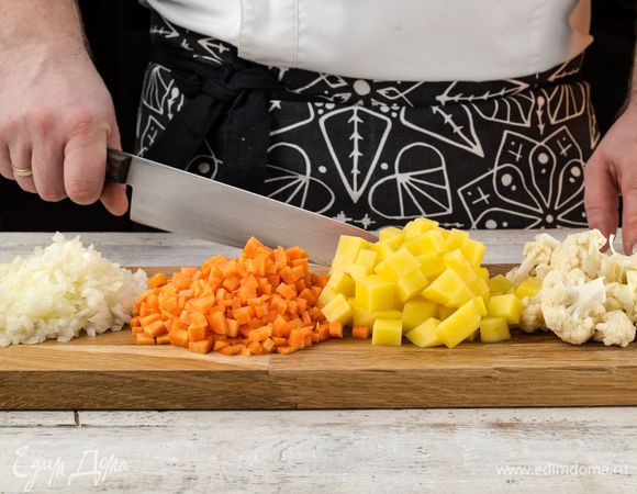 Овощи помыть и почистить. Лук, картофель и морковь нарезать кубиками. Цветную капусту разобрать на соцветия.