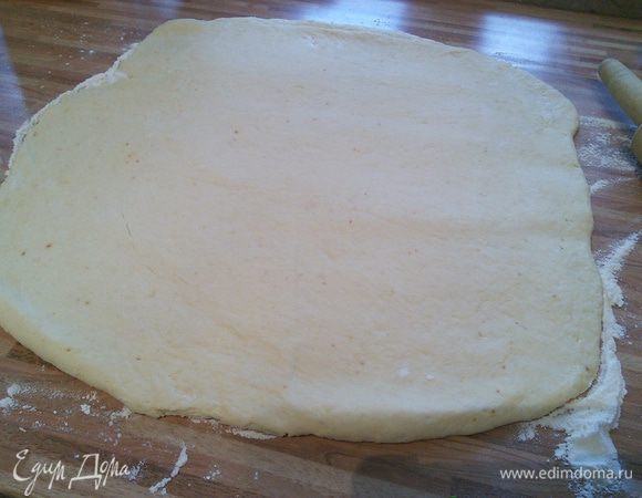 Чтобы было проще, присыпать мукой пергамент и раскатать тесто в прямоугольник. 
