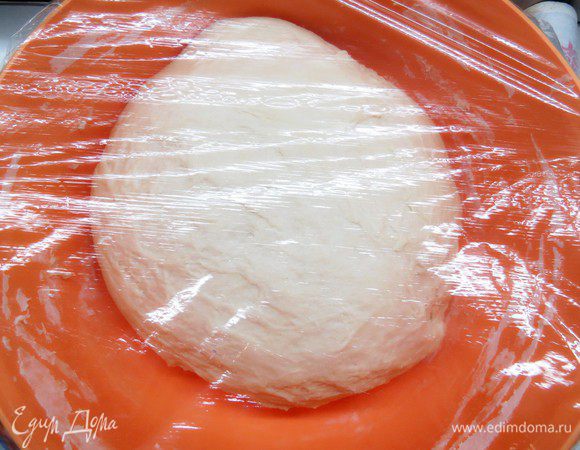 Через 20 минут выложить тесто на стол и быстро обмять, он станет гораздо более мягким и однородным. Затем возвращаем тесто в миску, накрываем пленкой и оставляем еще на 30 минут. 