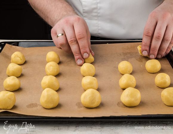 Из теста скатать маленькие шарики, выложить на противень, предварительно выстланный пергаментной бумагой.