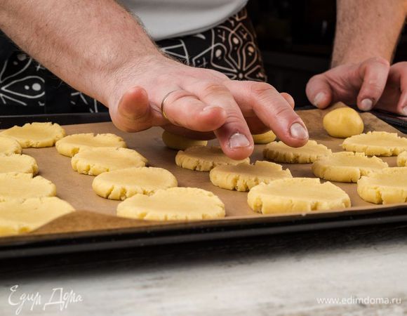 Шарики ладонью раздавить так, чтобы получились печенья. После чего поместить противень на 10 минут в разогретую духовку.