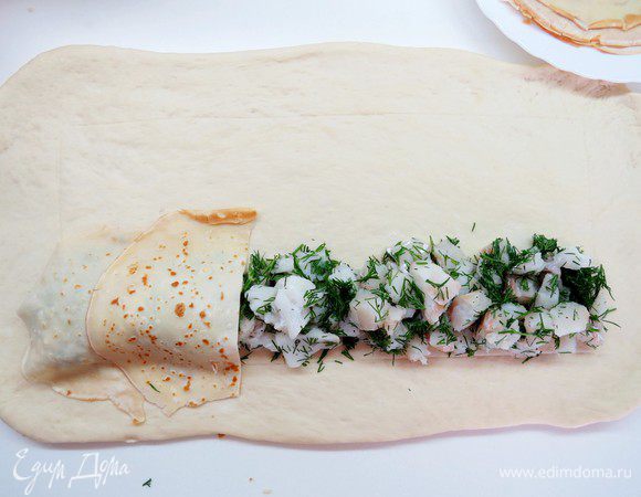 Аккуратно по краю намеченного прямоугольника выложить полоской шириною где-то 5 см первую начинку (у меня с треской) по всей длине прямоугольника.