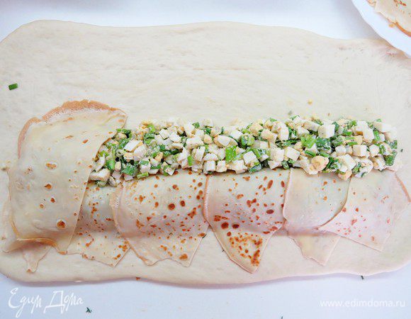 Следующий слой (у меня яичная начинка) выкладываем по всей длине до центра намеченного нами прямоугольника. Начинкой нужно немного покрыть первый слой, выложить её как бы углом (наискосок). Вторую начинку также покрываем наискосок блинчиками.