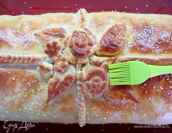 После расстойки выпекать пирог в нагретой духовке в течение 20 минут. Тем временем желток яйца размешать с небольшим количеством воды, вынуть пирог, смазать желточной смесью и посыпать кунжутом. Кулебяку прикрываем фольгой и ставим в духовку, перевернув противень, еще на 25 минут. 