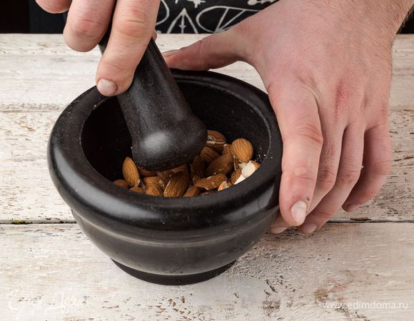 Миндаль измельчить в ступке в однородную крошку.