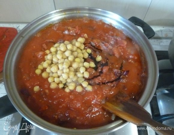 Добавить томатную пасту, томатное пюре, уксус, нут и немного кипятка. Довести до кипения, готовить на слабом огне 30 минут.