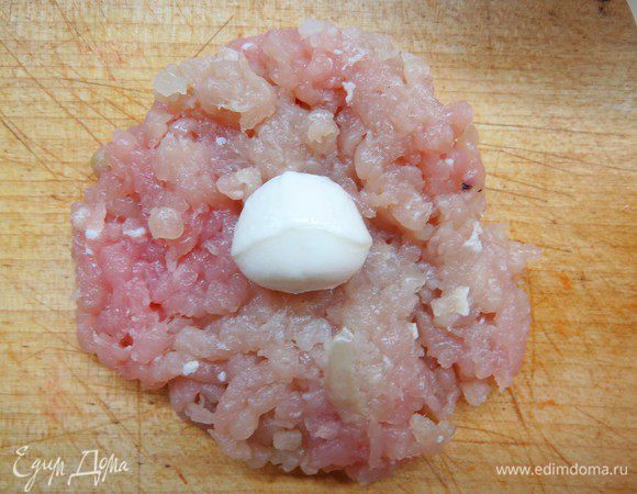 Из фарша сформировать небольшие лепешечки, на лепешечки выложить по шарику моцареллы и слепить тефтельку. 