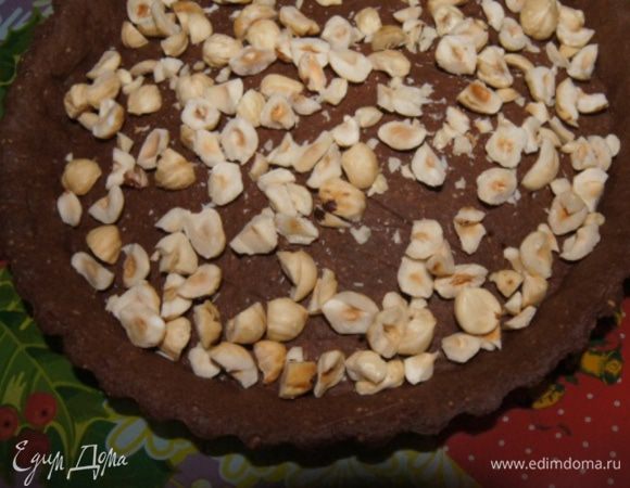 Духовку разогреть до 170°С и выпекать в ней основу для тарта около 17-20 минут. Остудить, достать основу из формы, переложить на блюдо и присыпать порубленным фундуком.