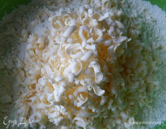 Натираем на крупной терке сливочное масло из холодильника. Руками перетираем масло с мукой в крошку.