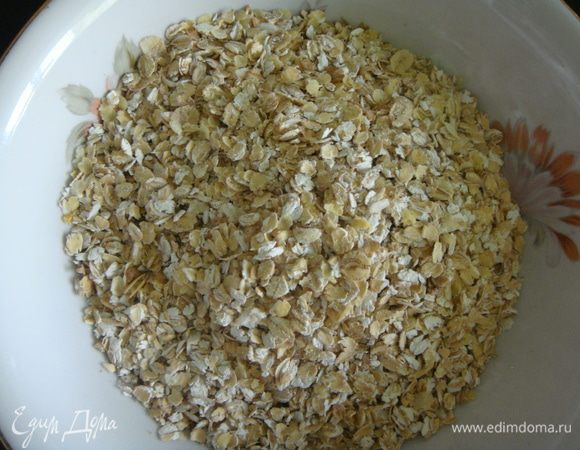 Овсяные хлопья всыпать в глубокую миску.