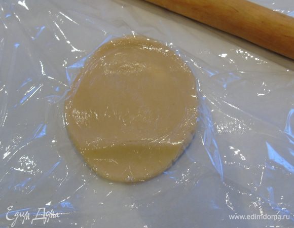 Разделите тесто на 6 частей. Каждую раскатайте прямо на пергаменте для выпечки, сверху  накрыв пленкой.