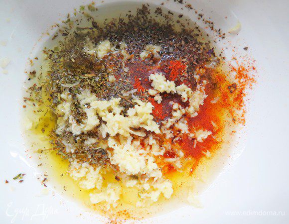 В посуде смешать растопленное сливочное и растительное масло, добавить все специи, соль, чеснок, выдавленный через чеснокодавку. Картофель выложить на противень или в посуду для запекания. Сверху выложить массу и хорошо перемешать.