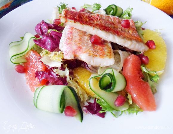 Сервируем блюдо. Выкладываем салат, теплое филе барабульки. Огурец нарежем тонкими лентами при помощи ножа для чистки овощей. Украшаем салат ленточками огурца и зернами граната. Очень вкусно и красиво! Приятного аппетита!
