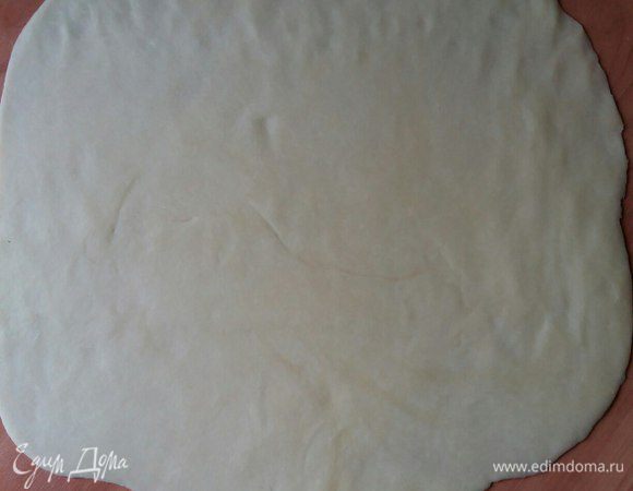 Теперь займемся лепкой пирога. Для этого готовое тесто разморозим. Возьмем 1 пласт. Раскатаем. Сделаем немного вытянутую форму.