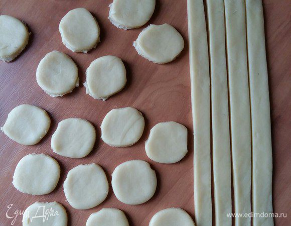 Берем второй пласт теста, так же раскатываем, как первое, и из него начинаем нарезать составляющие рыбки.
Полосочки шириной 1 см — бортики и кружочки рюмочкой, они будут чешуей рыбки. Бортики нужны, чтобы начинка в пироге легла хорошо и не вылезала за края теста. 