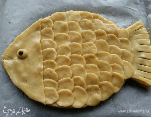 Смазываем всю рыбку яйцом, делаем шарик из теста — это глаз. Внутрь кладем горошину перца. Делаем прорезь — рот.