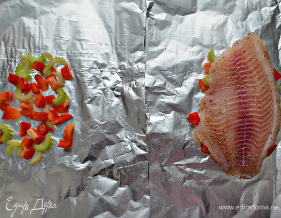Двойной слой фольги (прямоугольник примерно 30Х40 см) немного смажьте растительным маслом. Выложите порезанный перец с сельдереем, затем филе рыбы и сбрызните слегка лимонным соком.