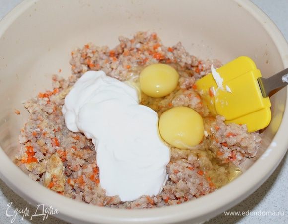 Добавляем сметану с яйцами, от сыра откладываем 3 ст. л., это пойдет на верх, а остальной сыр добавляем в фарш. Перемешиваем.
