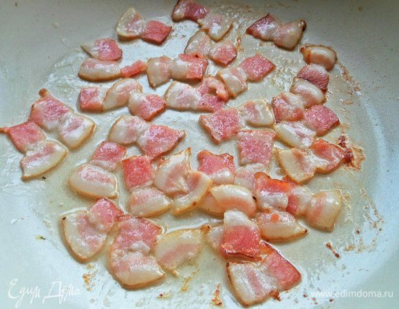 Бекон нарезать и высыпать в разогретую сковороду. Слегка обжарить.