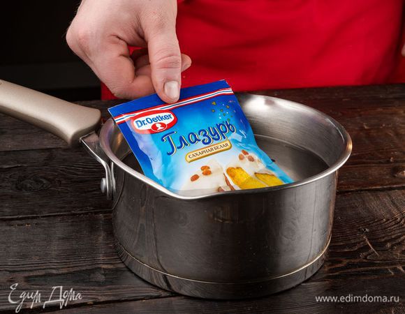 Приготовьте белую сахарную глазурь Dr. Oetker, опустив упаковку на 5 минут в горячую воду. Выложите упаковку на полотенце и несколько раз надавите на него, чтобы глазурь стала более мягкой и однородной.