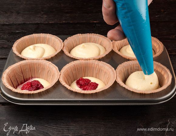 Залейте сверху тестом, оставив по 1 см до края формочки. Выпекайте маффины 20 минут в духовке при температуре 180°С. Остудите маффины и выньте их из формочек.
