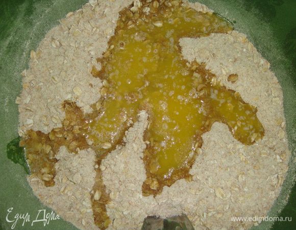 К сухим ингредиентам влить растопленное сливочное масло и добавить яйцо.