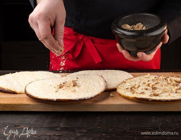 Посыпьте каждый корж измельченным миндалем.