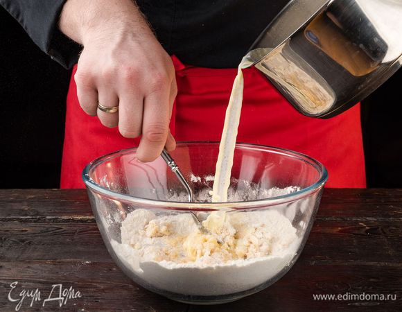 Сделайте углубление в муке и вбейте в него яйцо и желток. Вливая тонкой струйкой теплое молоко, замесите тесто.
