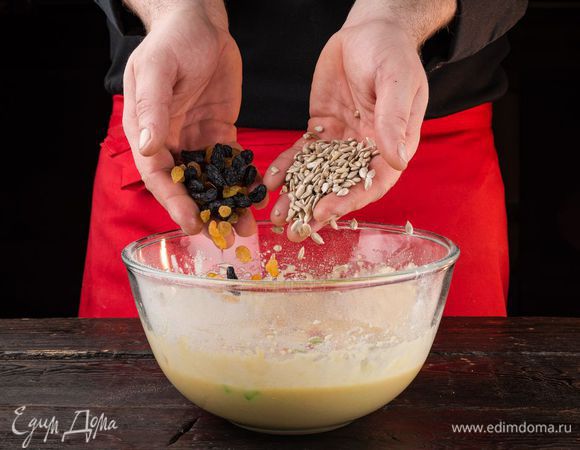 Добавьте изюм и подсолнечные семечки, хорошо перемешайте.