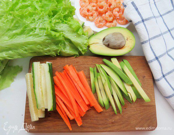 Подготавливаем овощную начинку. Авокадо, огурец и морковь нарезаем тонкими полосками. Листья салата моем и кладем обсушиться на полотенце.