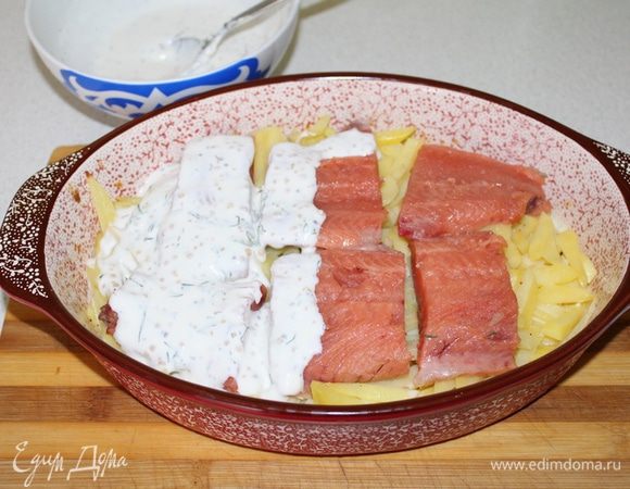 Вынуть форму, выложить филе рыбы, залить все сметанным соусом.