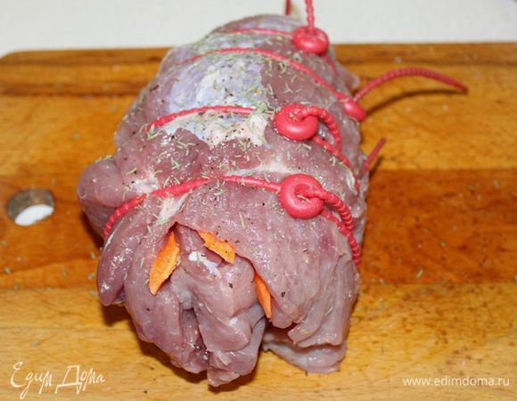 Очень туго свернуть мясо рулетом, крепко обмотать толстыми нитками или специальными жгутиками, сверху натереть солью и оставшимися травами.