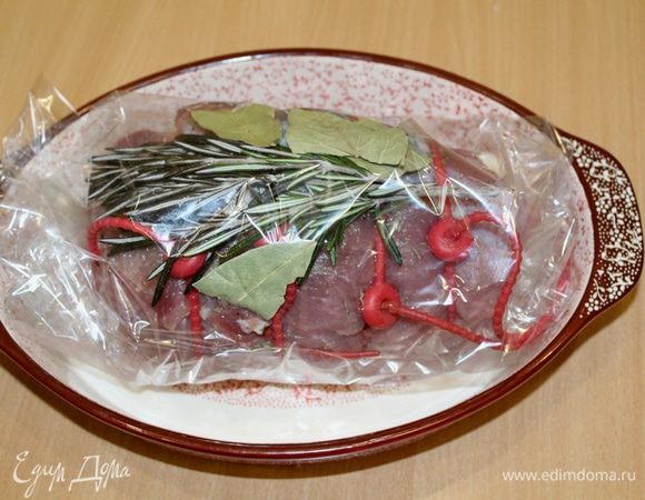 Вложить в рукав для запекания, сверху положить веточку розмарина и лавровый лист. Положить мясо в форму в пакете и убрать на ночь в холодильник.