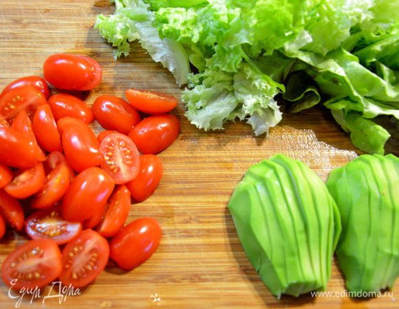 Помидорки черри разделить пополам. Авокадо разрезать вдоль. Салат помыть и просушить.