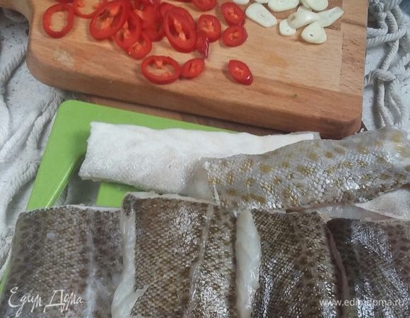 Красиво нарезаем перчик и чеснок. Режем тушку трески на порционные кусочки. Солим кусочки рыбы.