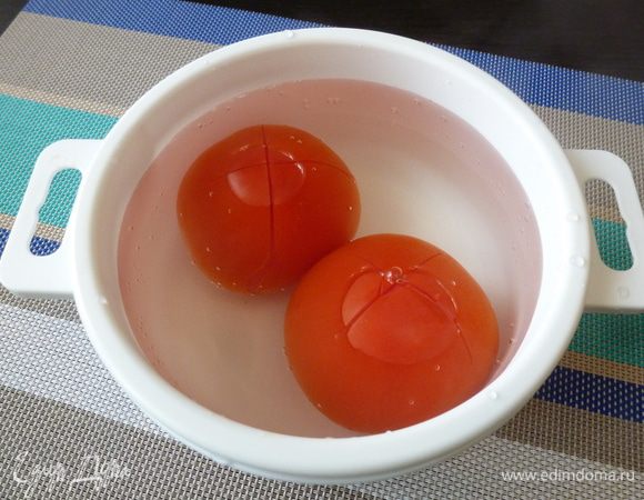Помидоры зальем кипятком на 1 минуту, предварительно надрезав с носика крестом. Охладим холодной водой.