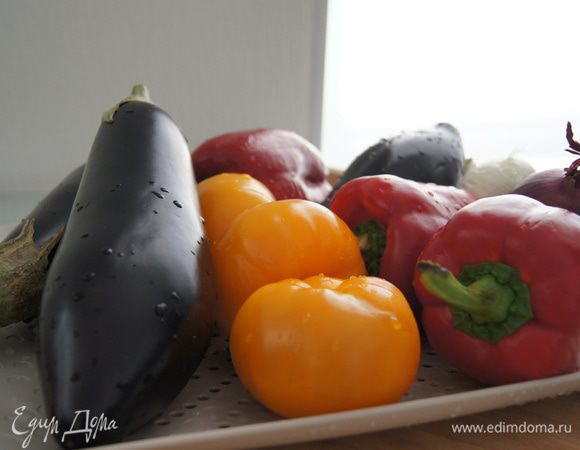 Разогреть духовку до 200°С. Подготовить овощи: помыть баклажаны, перцы, помидоры, лук.  Шелуху с лука не снимать.
