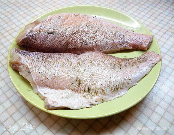 Разделяем на филе, делаем на коже поперечные разрезы и натираем смесью соли и перца. По желанию можно добавить свои любимые специи для рыбы.