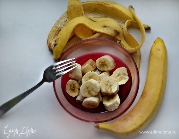 2 больших банана очистите от кожуры и разомните вилкой в пюре. 1 небольшой банан нарежьте тонкими кружочками, выложите на противень, покрытый пекарской бумагой, и немного подсушите в духовке.