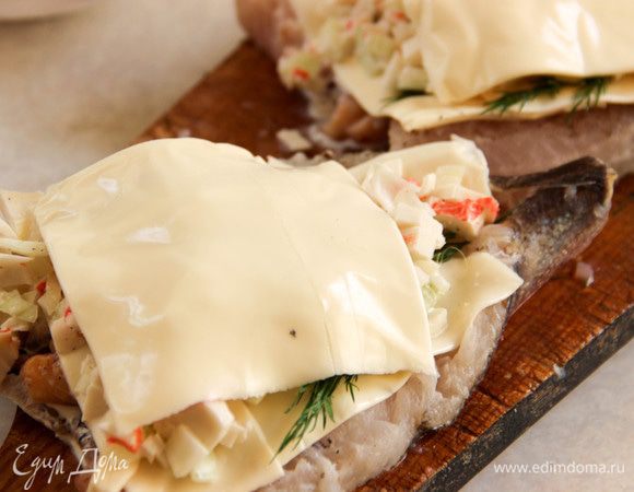 Прикрываем начинку сыром и отправляем хек в духовку на 30 минут.