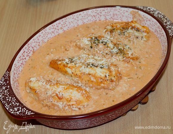 Заливаем соусом куриные грудки, посыпаем оставшимся сыром и запекаем при 180°С 30 минут.