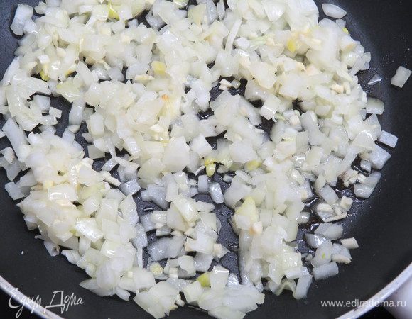 Разогреть в сковороде оливковое масло, добавить лук и чеснок, потушить на среднем огне 2-3 минуты, периодически помешивая.
