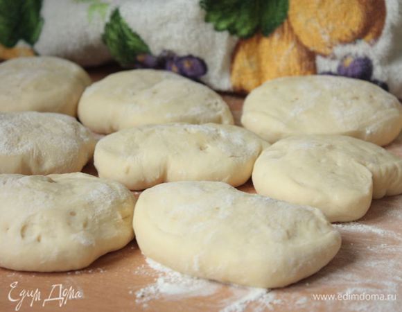 Разложите заготовки для булочек на припыленную мукой рабочую поверхность, накройте полотенцем и оставьте их расстаиваться на полчаса. 