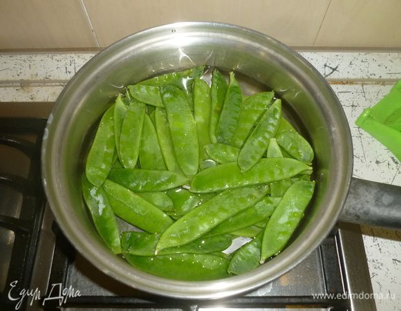 Бланшировать стручковый горошек в кипящей воде 1 минуту. Откинуть на сито. Нарезать тонкими полосками.