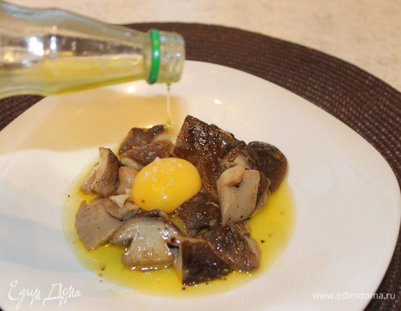 На теплую сервировочную тарелку положите грибы вместе с соусом, который получился в процессе приготовления. Отделите тщательно желток от белка так, чтобы желток остался целым, аккуратно положите его сверху на грибы. Посыпьте блюдо морской солью и полейте  трюфельным маслом.
Подавайте блюдо к столу.