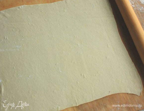Прямоугольную форму (длиной 25 см, на 1,5 литра) выстлать пекарской бумагой. Слоеное тесто раскатать примерно 32 х 32 см и на скалке перенести в форму.