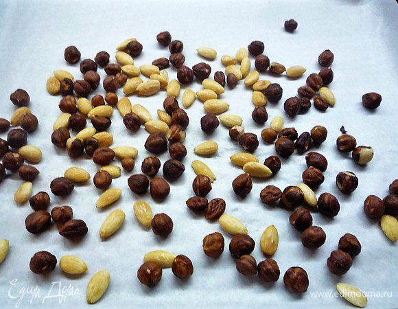 Приготовим пралине. Орехи выкладываем на противень, застеленный пекарской бумагой, и запекаем в духовке, разогретой до 200°С, в течение 10 минут.